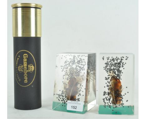 A Game bore cigar humidor, modelled as a shotgun cartridge, with screw off lid, 24cm high and a pair of cast epoxy resin book