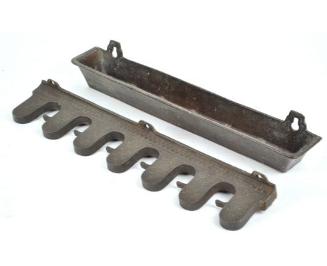 A 19th century cast iron rack for six billiard cues consisting of a base pan and a top decorated with scale motifs and turn-s