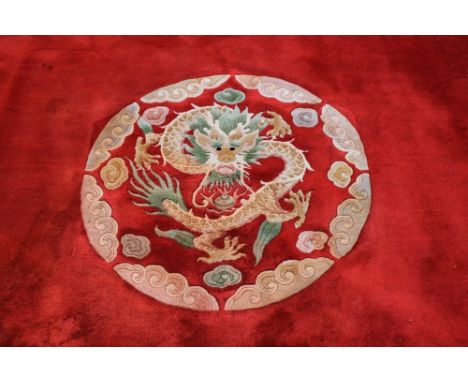 A LARGE AND IMPRESSIVE CHINESE WOOLLEN RUG, with scrolling dragons on a red ground, 371 x 276 cm (excluding fringe)