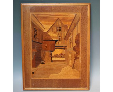 A 20TH CENTURY ARTS & CRAFTS STYLE INLAID SPECIMEN WOOD PANEL, depicting a Tudor style coaching inn, framed, 42 x 32 cm