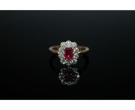 AN 18 CARAT RUBY AND DIAMOND RING, set with an oval ruby of approx 0.75 carat and surrounded by approx 0.50 carat of brillian