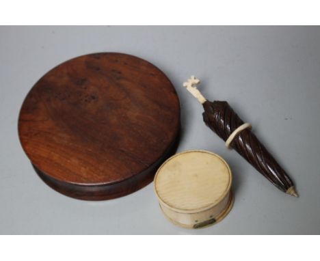 A GEORGIAN YEW WOOD CIRCULAR SNUFF BOX, Dia 10 cm, together with a smaller oval snuff box and a carved needle case in the for