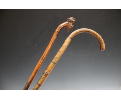 A FOLK ART WALKING STICK WITH PAINTED FIGURAL AND LANDSCAPE DECORATION, together with a walking cane with the pommel carved i