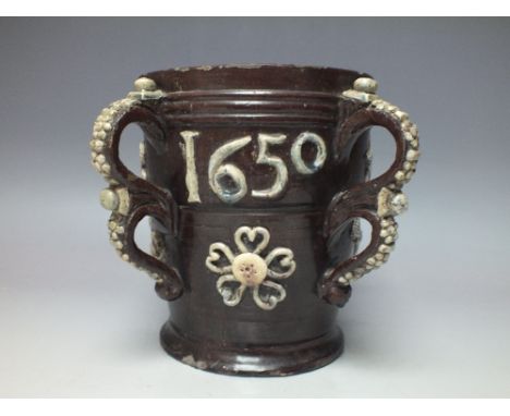 A WROTHAM STYLE SLIPWARE FOUR HANDLED TYG INITIALLED AND DATED 'G R 1650', of tapering form with double loop handles having a