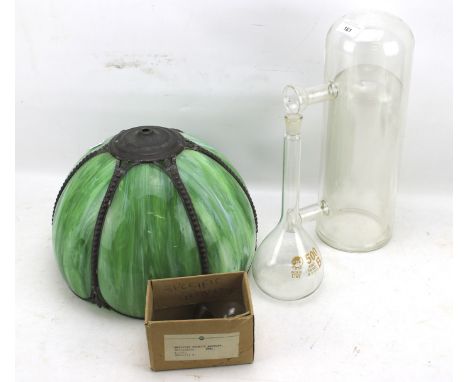 An assortment of glassware. Including a green a lamp shade, a measuring vase etc