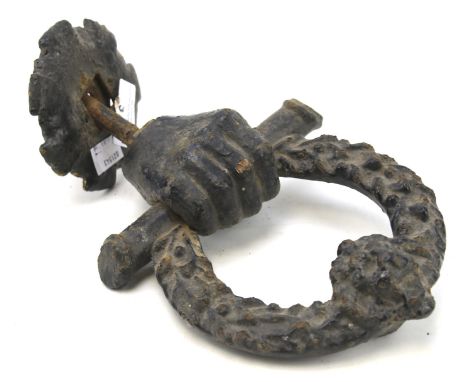 An early 19th century cast metal door knocker. Modelled as a hand holding a wreath bearing a lion's head, H25cm