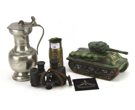 An assortment of military collectables. Including an engraved goblet, fabric patch, trench art shell case, etc.