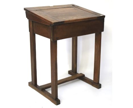 A vintage oak child's school desk. With an adjustable top and placed on stretchers, L61cm x D50cm x H85cm