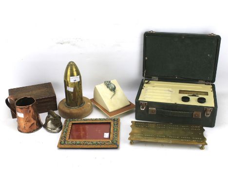 An assortment of collectables. Including a large military shell case, brass tankard, ceramic cheese dish, a cribbage board et
