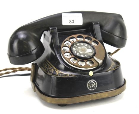 A vintage Belgium telephone. In black with gilt decoration with the M.F.C. company logo to the side, H15cm