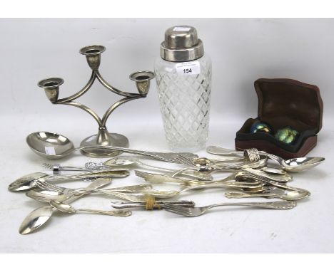 An assortment of silver plate. Including a candlestick, cocktail shaker and flatware, together with a pair of glass apples wi