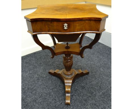 A Victorian mahogany sewing table, raised on a carved tripod base, the hinged lid revealing an arrangement of fourteen rose-w