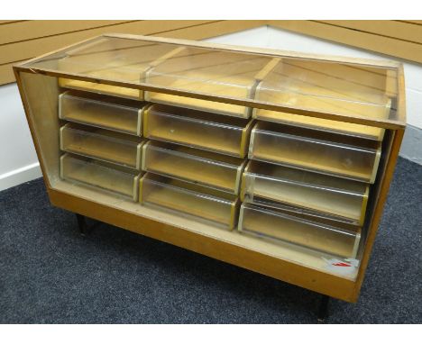 A smaller late twentieth century light wood and glass retailer's counter display raised on metal supports and containing a fu