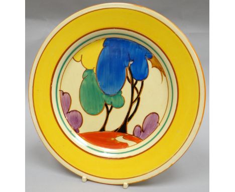 A Clarice Cliff  'Autumn' display plate in bright yellow glaze and colourful landscape to the interior, 9 ins diam (23 cms)