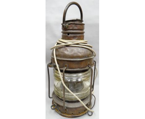 A copper ship's mast head lamp with loop handle and ribbed glass lantern (distressed), 24 ins high (61 cms)