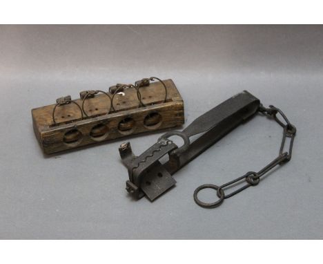Two vintage traps, a wooden four aperture mouse trap together with a small leg hold trap.