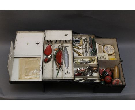 A vintage metal fishing tackle box, black japanned with silver fish motif to the lid opening to various compartments, filled 