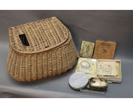 A vintage wicker fishing creel filled with Hardy, Mallochs, and other cast wallets, Lochleven fly box, Simalloy boxes etc.