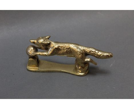 A brass door knocker in the form of a running fox, length nose to tail 13 cm.