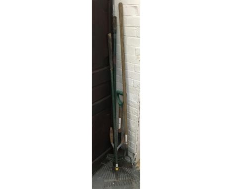 A number of long handled tools comprising rakes, hoe, spade etc 