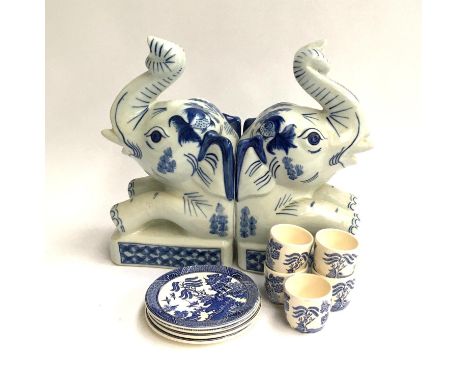 A pair of ceramic elephant bookends, together with four blue and white willow pattern coasters and five small teacups