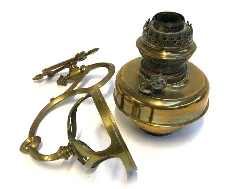 A brass wall mounted oil lamp with hinged bracket 