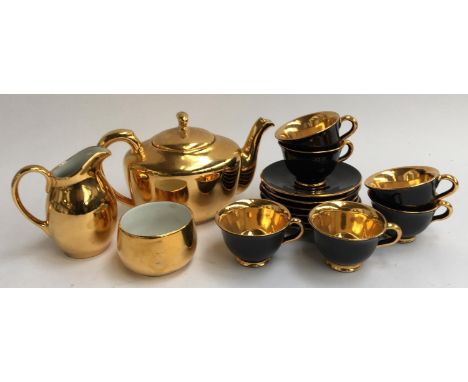 A Royal Worcester three piece gilt tea set; together with a gilt and black Italian cups and saucer set 