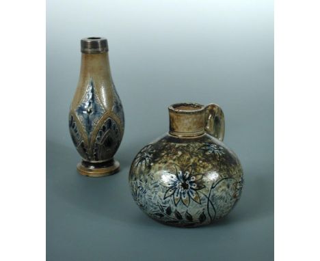 A Martin Brothers stoneware jug and a specimen vase, the jug with blue flowerheads and loop handle, inscribed to underside '5
