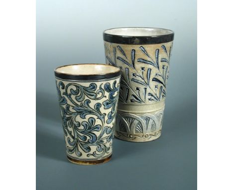 Two Martin Brothers stoneware beakers, the larger with silver mounted rim above grass heads, an arcaded band below, inscribed