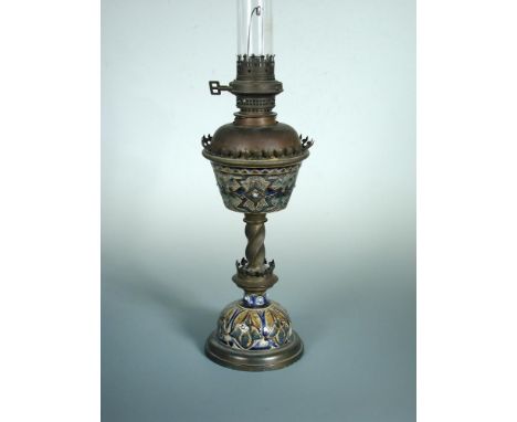A Doulton Lambeth stoneware oil lamp, with incised and applied foliate decoration to the resevoir and base, united by a twist