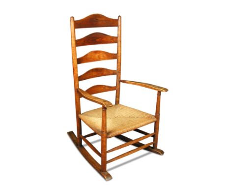 After Ernest Gimson, an ash and elm rocking chair, the ladder back above a corded rush seat 102 x 57cm (40 x 22in)  