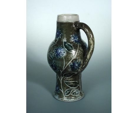 A Martin Brothers stoneware jug, the bulbous body decorated with blue flowerheads to a green ground, inscribed to underside '