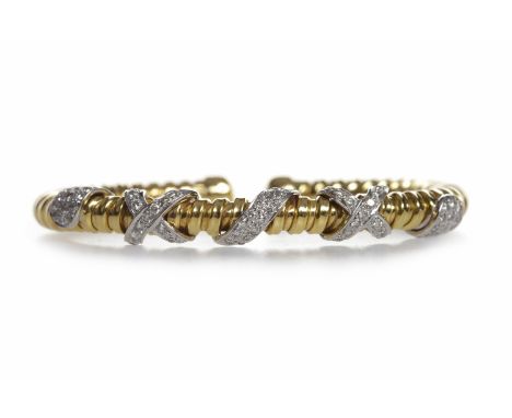 EIGHTEEN CARAT GOLD DIAMOND SET TORQUE BANGLE
with diamond set crossover sections, the stones totalling approximately 0.70 ca