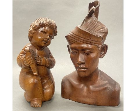 An Indonesian carved hardwood bust of a young man, H. 36cm. Together with a carved hardwood figure of a cherub playing a harp
