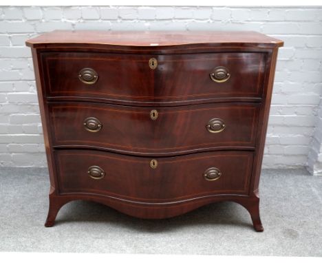 A late George III inlaid mahogany serpentine chest of three long graduated drawers, on splayed bracket feet, 125cm wide x 101