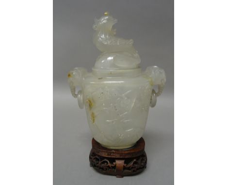 A small Chinese agate two-handled vase and cover of light grey tone with russet inclusions, decorated in relief with a deer a