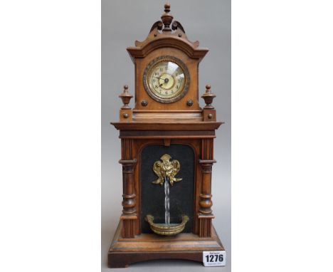 A Black Forest novelty mantel clock, early 20th century, the arched hood enclosing dial and movement over a body with automat