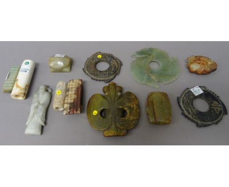 A group of pieces of Chinese jade, various colours and forms, including; three notched discs (xuanji); a sword slide, two cyl