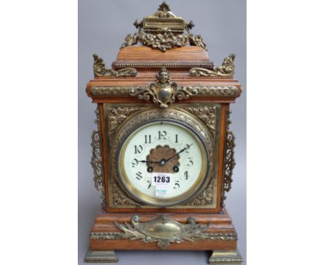 A Continental oak cased 8 day mantel clock, early 20th century, with enamel dial and gilt metal embellishments and a two trai