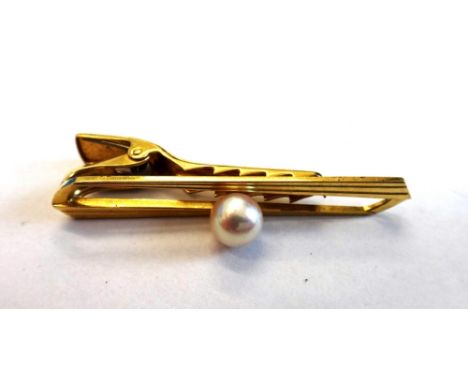 A gentleman's gold tie clip, mounted with a central cultured pearl, detailed K 14, by Mikimoto, gross weight 6.5 gms.