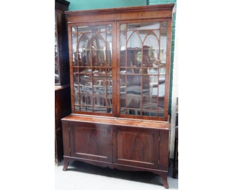 A George III mahogany bookcase display cabinet, the pair of Gothic arch astragal glazed doors over a pair of lower panel cupb