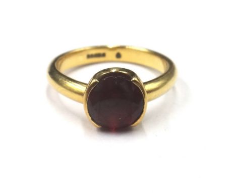 An 18ct gold ring, claw set with a circular cut garnet, ring size K, gross weight 4.7 gms.