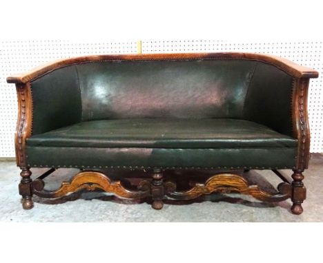 A 20th century oak framed two seat sofa with faux studded green leather upholstery, 123cm wide.   L7