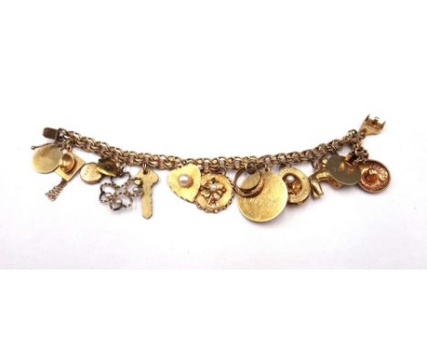 A gold multiple link bracelet, on a snap clasp, detailed 14 K, fitted with a variety of gold and other charms and pendants, i