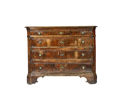 A 17th century North Italian walnut commode, with four long graduated drawers, flanked by canted corners, on bracket feet, 14