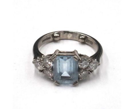 An 18ct white gold, aquamarine and diamond ring, claw set with the cut cornered rectangular step cut aquamarine between circu