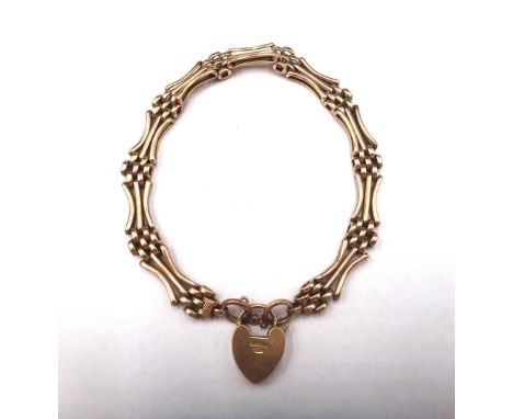 A gold curved bar and oval link gate bracelet, detailed 15 CT, on a gold heart shaped padlock clasp, detailed 15 C, weight 13
