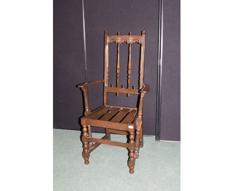 Ercol elbow chair, with arch carved back, on turned legs and flattened stretchers