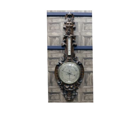 LARGE 19TH CENTURY OAK BAROMETER OF BAVARIAN DESIGNthe pediment carved with the face of a Bacchanalian type figure, the mercu