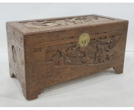 20th century carved Chinese camphorwood lined coffer with various figures amongst pagodas to the lid, the whole raised on bra